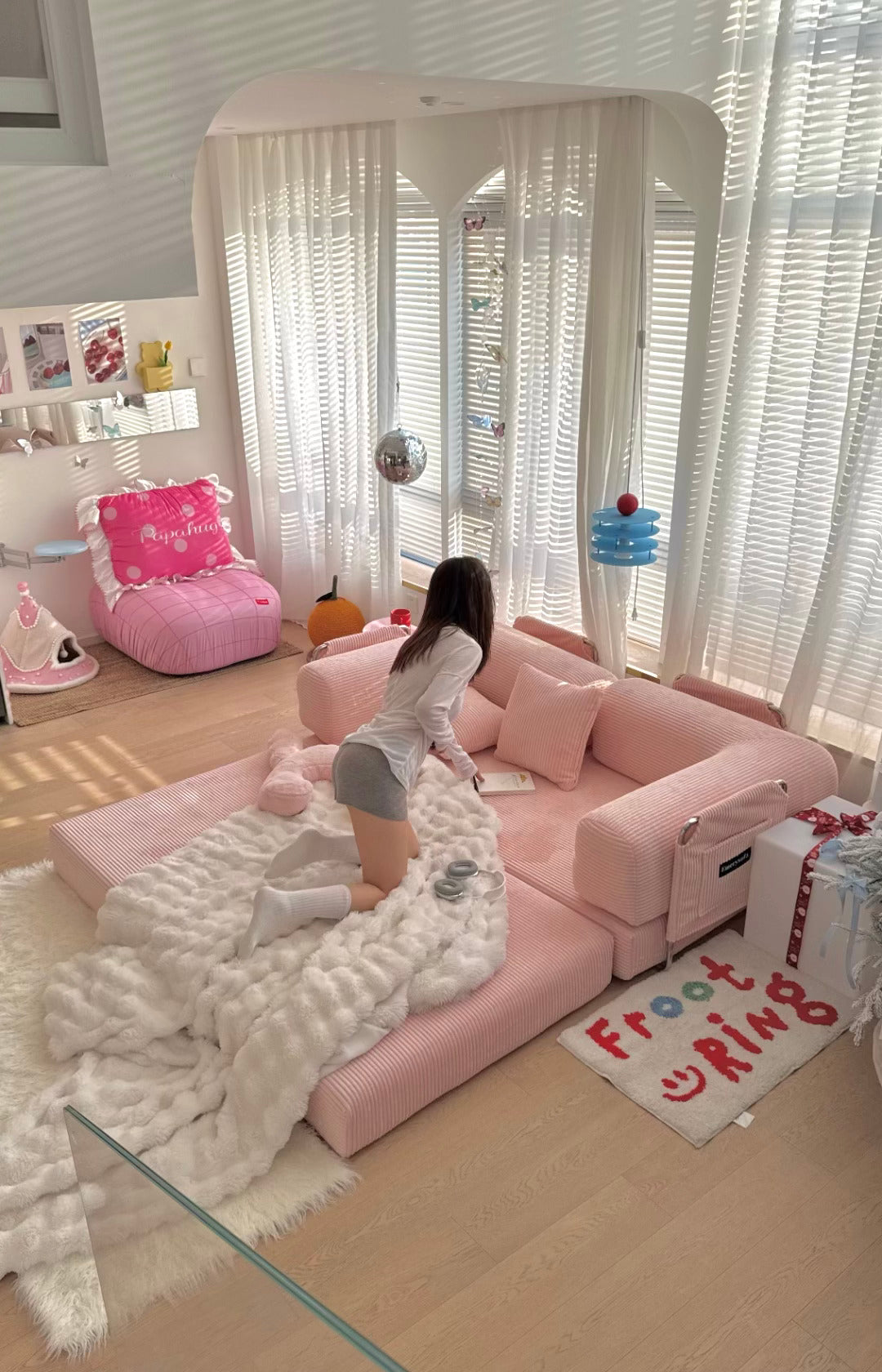 Pink living room with a child playing on a pink sofa